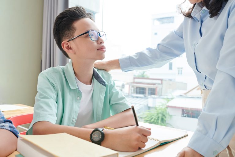 A teacher encouraging a student in a classroom